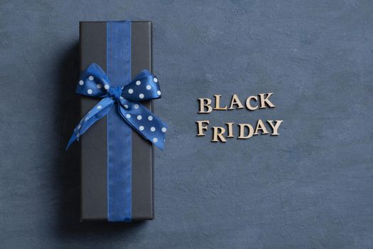 Black Friday text with gift flat lay on dark cement background. Top view