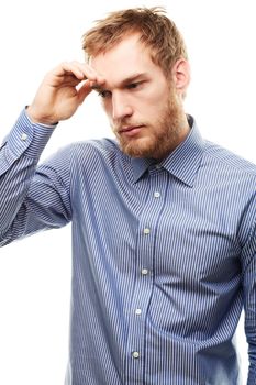 Searching for solutions. A worried looking young man touching his forehead isolated on white.