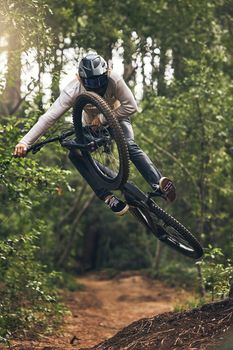 Sports, adventure and forest with man and mountain biking on park trail for action, freedom and fitness. Jump, speed and fast with athlete training in nature for exercise, health and workout
