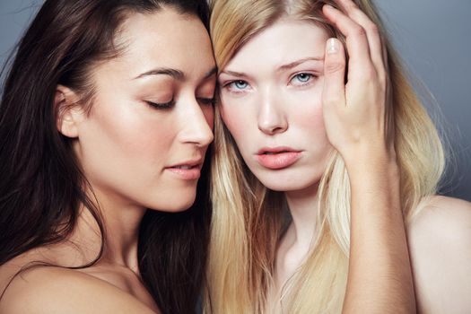 I will always take care of you. Portrait of a blonde woman with a brunette woman holding her face lovingly.