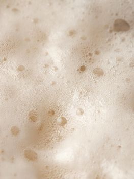 Beer foam top view. Soft fresh Foam on light beer. Bubble froth of beer. Beer foam texture background