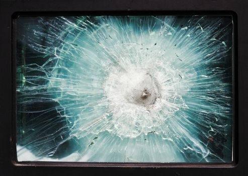 Bulletproof glass. Armored car after the shelling. Armored glass after of a direct hit from an automatic weapon. Safety glass after being hit by a bullet.