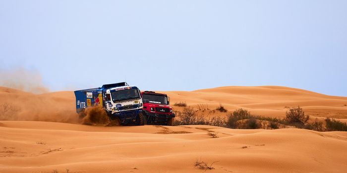 The rivalry between Kamaz and Maz at the rally. Sports truck KAMAZ gets over the difficult part of the route during the Rally raid in sand. THE GOLD OF KAGAN-2021. 26.04.2021 Astrakhan, Russia