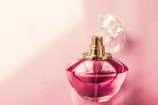 Pink perfume bottle on glossy background, sweet floral scent, glamour fragrance and eau de parfum as holiday gift and luxury beauty cosmetics brand design