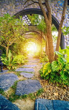 garden with natural arch entrance and sun rays, magical door gates in fabulous green forest