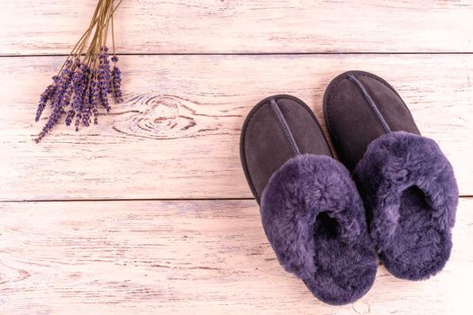 Soft blue woolen cozy slippers with lavender on wooden  background