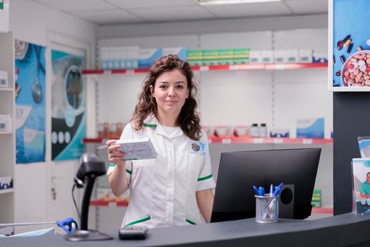Smiling pharmacy worker looking at camera while working in drugstore