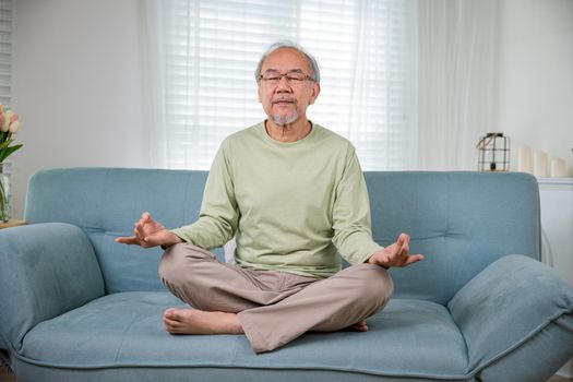 Asian old man practise yoga and meditation in lotus position and closed eyes