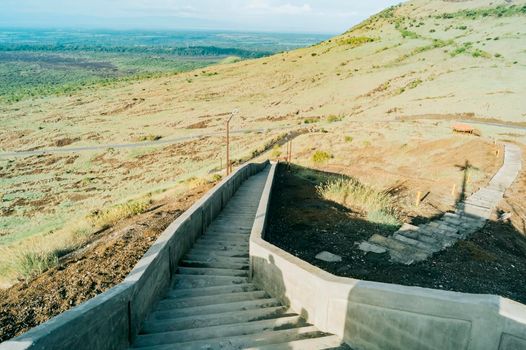 High angle of long concrete stairs outside with nature background. Long concrete stairs on a beautiful hill. Long stairs leading to the viewpoint of the Masaya volcano, Nicaragua