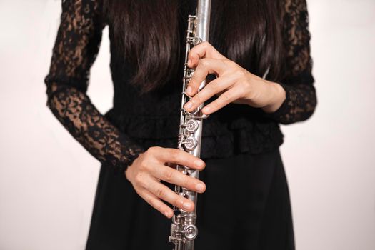 Close up of the hands of a female flutist while correctly holding her instrument