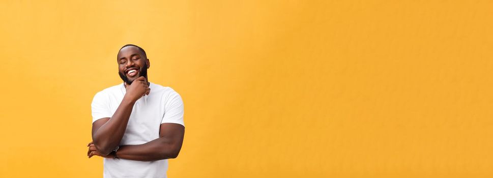 Portrait of a modern young black man smiling with arms crossed on isolated yellow background