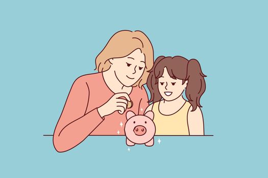 Mother and daughter put coin in piggybank