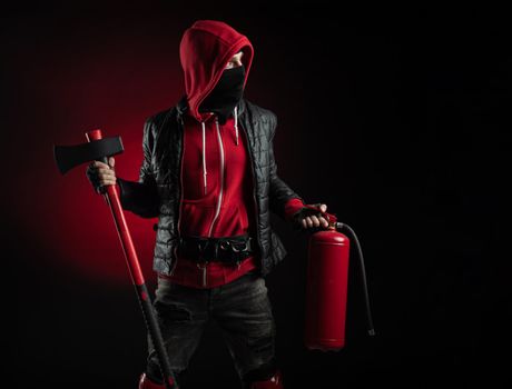 a man in a Balaclava and hoodie with an axe and a fire extinguisher the image of a Protestant