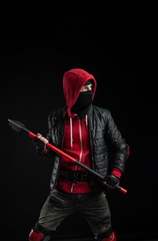 a man in a Balaclava and hoodie with an axe the image of a Protestant