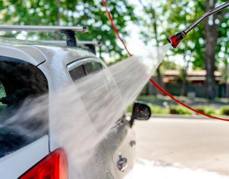Shot of a man washing his car