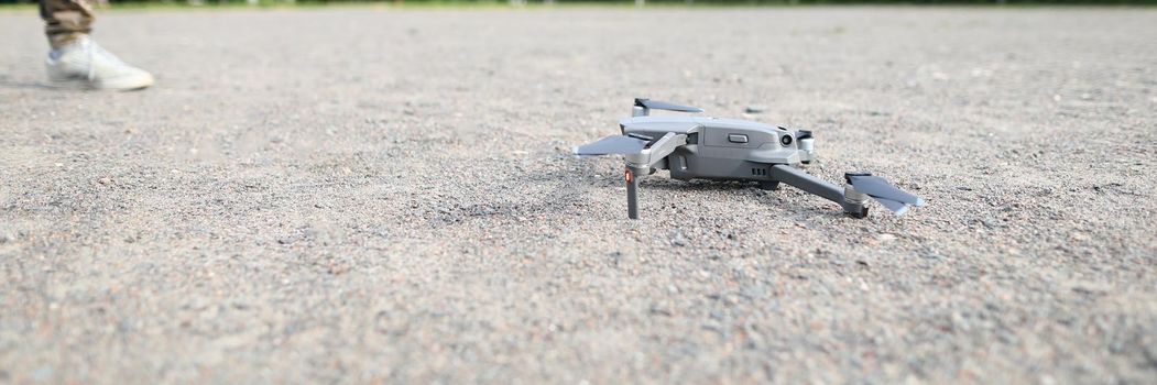 Small digital drone stands on ground closeup