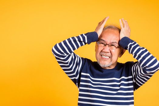 Asian elder man hands holding head and close ears suffering from headache