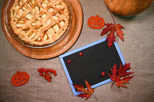 Top view blackboard with copy space, and pumpkin pie with crispy crust lattice for Thanksgiving Day, on linen tablecloth