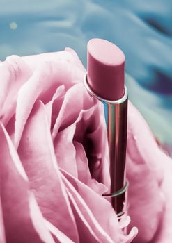 Pink lipstick and rose flower on liquid background, waterproof glamour make-up and lip gloss cosmetics product for luxury beauty brand holiday design