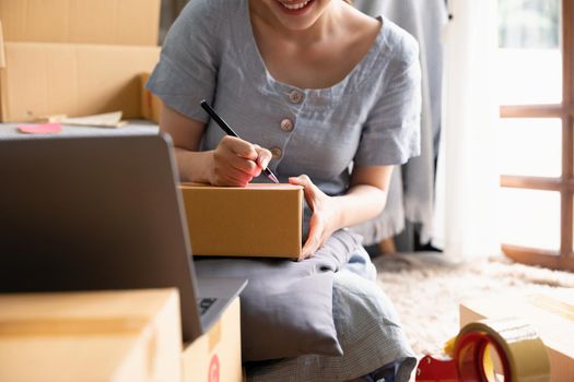 Small businesses SME owners female entrepreneurs writing address on receipt box and check online orders to prepare to pack the boxes, sell to customers, sme business ideas online.