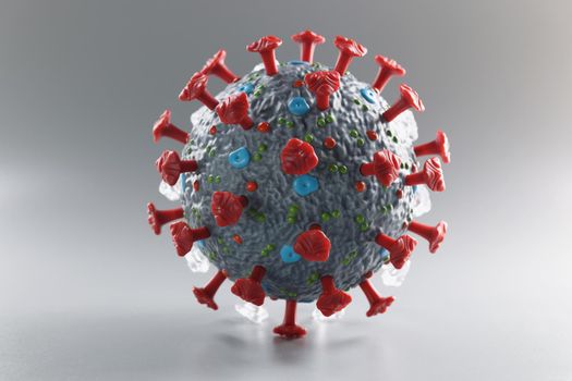Plastic model of coronavirus on a gray background