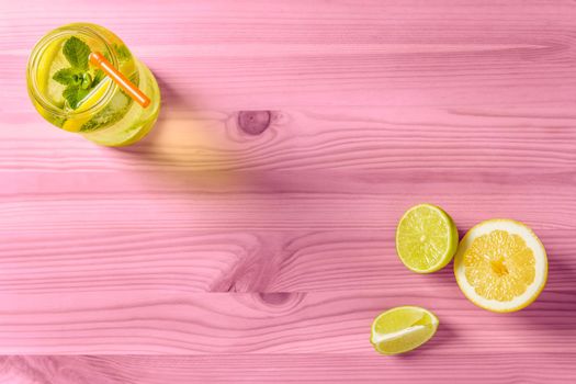 Lemon refreshment for summer on pink wooden table