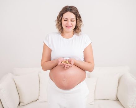 Pregnant woman holding a handful of walnuts.