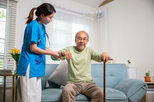 Young woman help support orthopedic patients to get up with walking cane at home