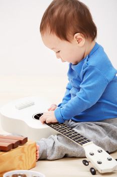 Hes got the gift. an adorable baby boy playing with a musical toy instruments.