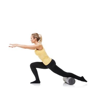 Lunging and stretching. A young woman performing lunges while using a foam roller - isolated.
