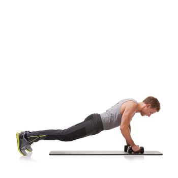 Toning his chest muscles. A fit young man doing push-ups with a pair of dumbbells.