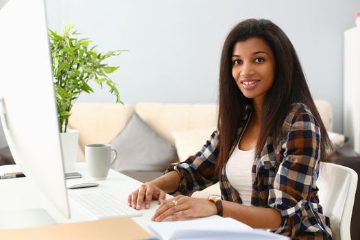 Positive afro business woman smiling at workplace at home