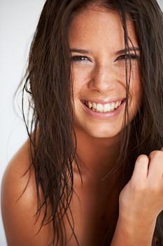 Fresh-faced and beautiful. Portrait of an attractive young woman with wet hair smiling at the camera.