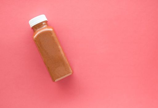 Detox superfood chocolate smoothie bottle for weight loss cleanse on.coral background, flatlay design for food and nutrition expert blog