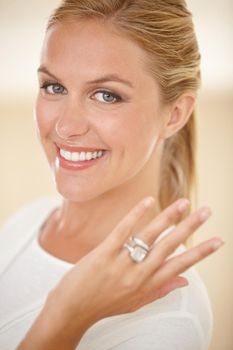 He finally popped the question. Portrait of an attractive young woman showing off her engagement ring.