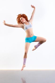 Expressing her passion. Young woman dancing against a white background.