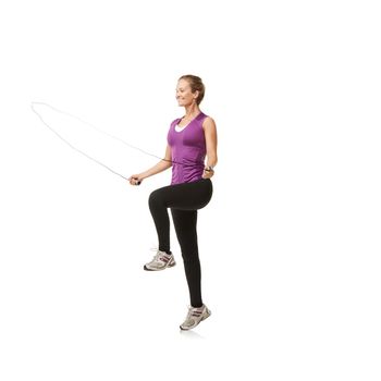 Jumping rope is THE best exercise. An attractive young woman smiling while skipping.