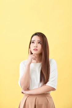 Young business woman thinking making choice, isolated on yellow