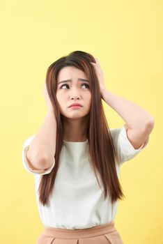 Portrait of woman confused damaged dry hair on yellow background