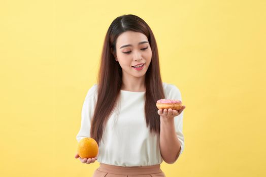 Woman holding orange and donut cake

