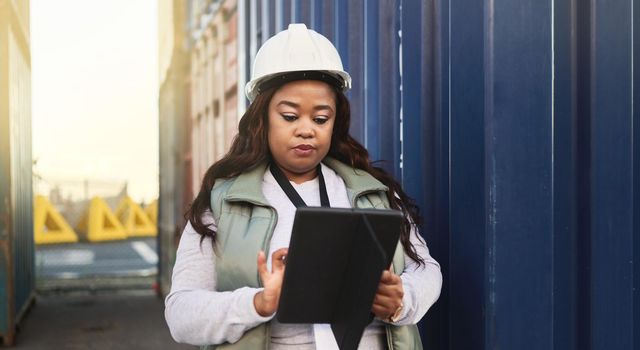 Logistics, business and black woman shipping containers being check or inspect cargo for transport. Female boss or worker with tablet confirm import, export or shipment for international supply chain