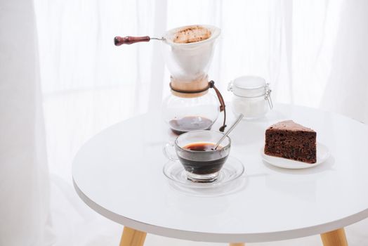 Drip coffee (dripper) and drip ground coffee with glass drip pot, cup and chocolate cake