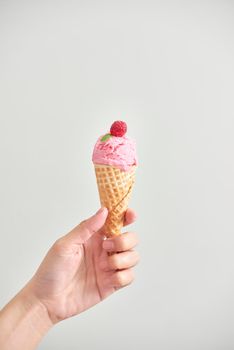 Ice cream cone isolated. The woman holding the ice cream by hand.
