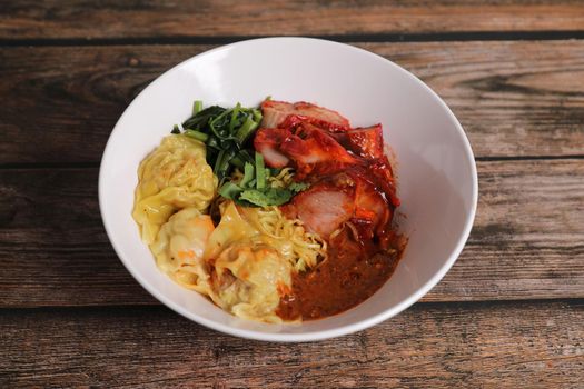 Shrimp dumpling with roasted pork with local thai tom yum spicy sauce on wood background