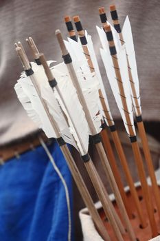 Wooden arrows for the bow. Hand crafted arrows in medieval style. Arrows with feather plumage in archer's quiver. Historical reconstruction - arrows for the bow. Medieval set of archer