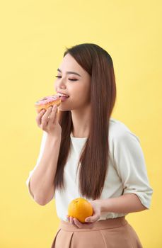 Woman holding orange and donut cake
