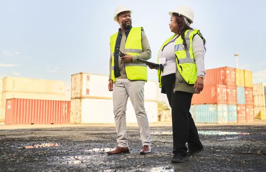 Logistics, supply chain and engineer team in shipping cargo industry walking, talking and doing inspection on shipyard. Black man and woman in industrial container site for export and import planning