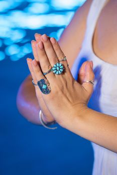 Woman holding namaste in clean water. Palms with gypsy boho rings. Meditation, praying, gratitude, purity background.