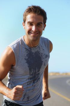 I love these morning jogs. Handsome young athlete smiling at the camera while jogging.