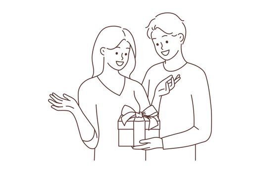 Loving man greeting woman with present